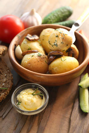 Young boiled potatoes in bowl on wooden table, close upの写真素材
