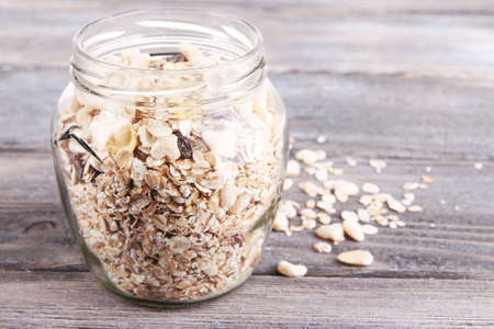 Homemade granola in glass jar, on color wooden backgroundの写真素材