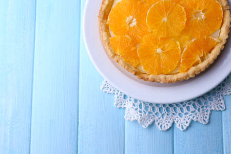 Homemade orange tart on plate, on color wooden backgroundの写真素材