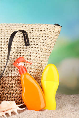 Summer wicker bag with accessories on sand, on nature backgroundの写真素材