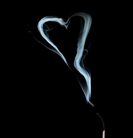 Abstract smoke in shape of heart on black  backgroundの写真素材
