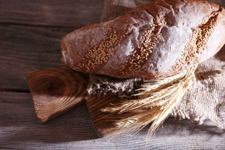 Fresh baked bread and ear of wheat, on wooden backgroundの写真素材
