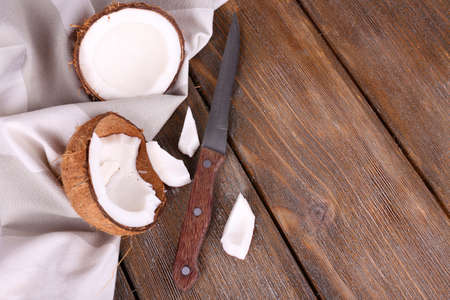 Broken coconut with knife and napkin on wooden backgroundの写真素材