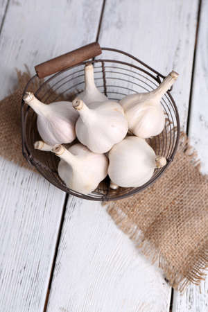 Fresh garlic in basket, on wooden backgroundの写真素材