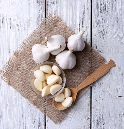 Fresh sliced garlic in glass bowl on wooden backgroundの写真素材