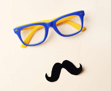 Glasses and mustache forming man face on beige backgroundの写真素材