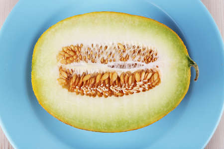 Melon on blue plate on wooden backgroundの写真素材