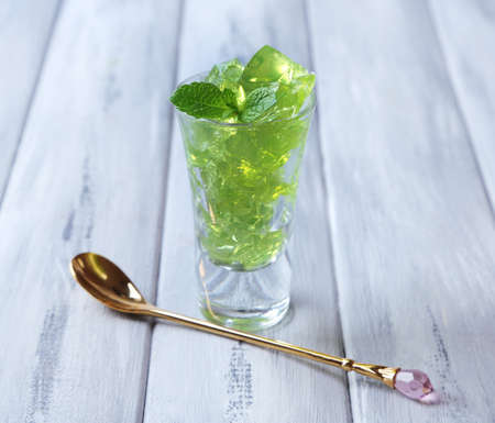 Green jelly with mint leaves in glass on wooden backgroundの写真素材