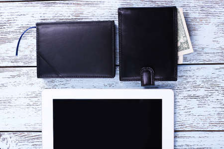 Tablet, wallet with money and notebook on wooden backgroundの写真素材