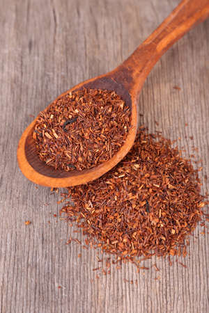 Dried rooibos tea in spoon on wooden tableの写真素材
