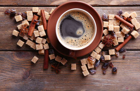 Brown sugar, spices and cup of coffee on wooden backgroundの写真素材