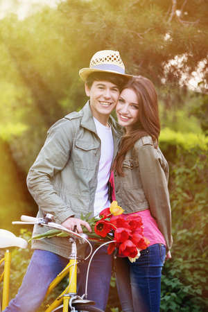 Young couple with bicycle in parkの写真素材