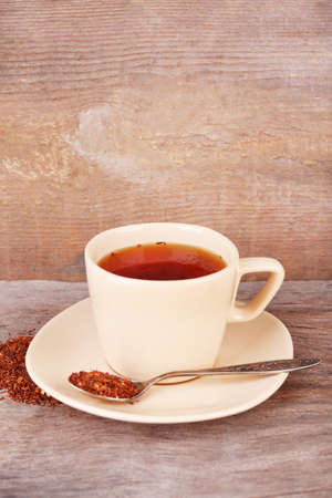 Cup of tasty rooibos tea, on wooden tableの写真素材