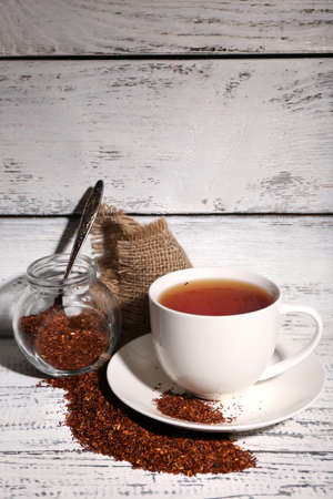 Cup of tasty rooibos tea, on old white wooden tableの写真素材