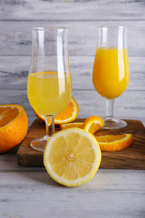 glasses of juice with fresh fruits on grey wooden tableの写真素材