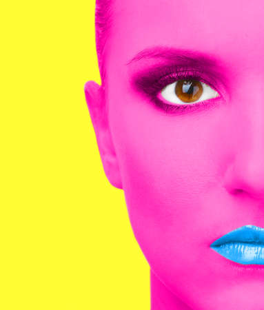 Portrait of woman with pink skin and blue lips on yellow backgroundの写真素材