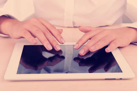 Woman using digital tablet on light backgroundの写真素材