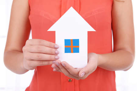 Woman hands holding paper house on light backgroundの写真素材