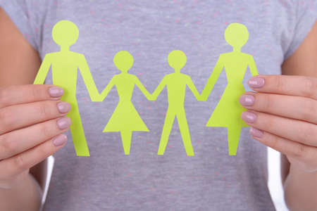 Woman hands holding paper family close upの写真素材
