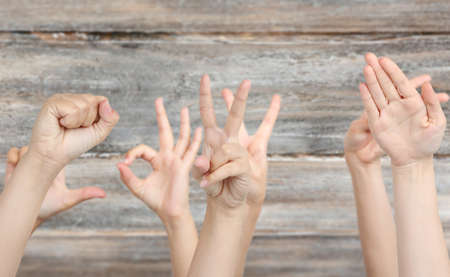Young people's hands on wooden backgroundの写真素材