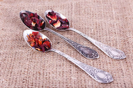 Tea in spoons on sackcloth fabric backgroundの写真素材