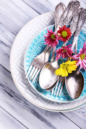 Plates and vintage cutlery on color wooden backgroundの写真素材