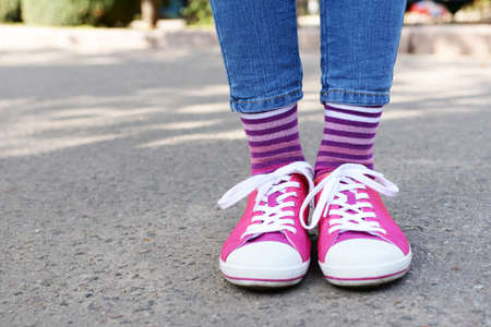 Female legs in colorful socks and sneakers outdoorsの写真素材