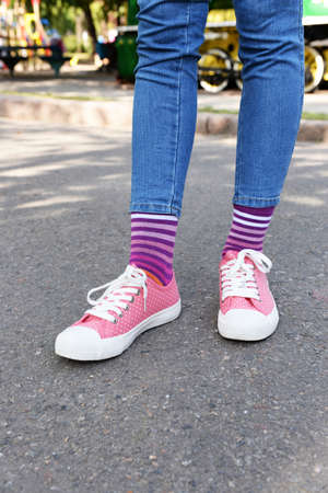 Female legs in colorful socks and sneakers outdoorsの写真素材