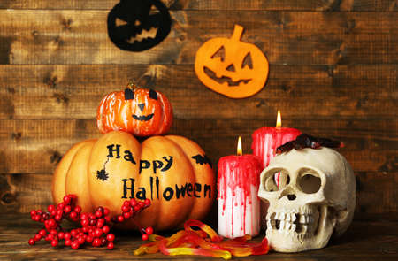 Halloween pumpkins and candles on wooden table backgroundの写真素材
