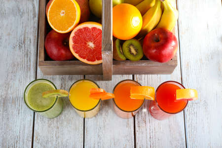 Fruit and vegetable juice and fresh vegetables on napkin on wooden backgroundの写真素材