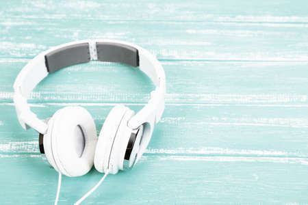 White headphones on wooden table close-upの写真素材