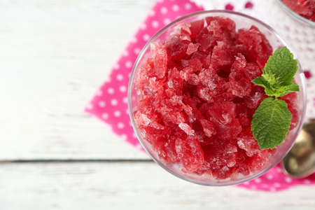 Closeup of cherry granita in glass bowl, on color wooden backgroundの写真素材