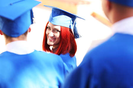 Graduate students wearing graduation hat and gown, outdoorsの写真素材