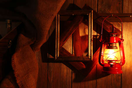 Lantern hanging on hook on wooden wallの写真素材
