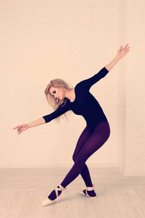 Beautiful young ballerina on wall backgroundの写真素材