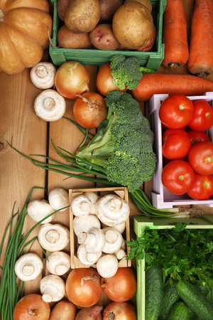 Different vegetables in boxes on wooden background top viewの写真素材