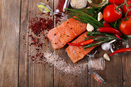 Fresh salmon with spices on wooden tableの写真素材