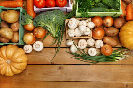 Different vegetables in boxes on wooden background top viewの写真素材