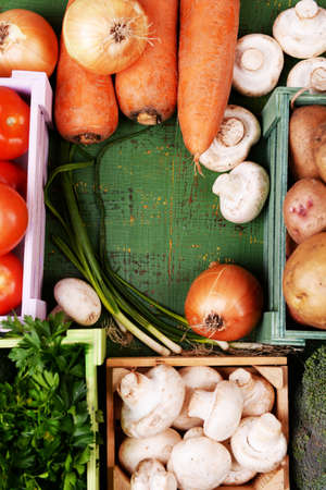 Different vegetables in boxes on wooden background top viewの写真素材