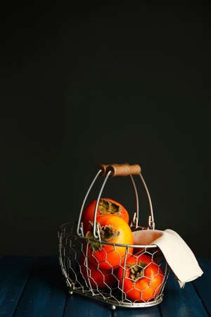 Ripe sweet persimmons, on wooden tableの写真素材