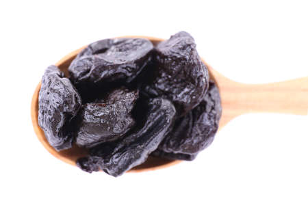Wooden spoon of prunes isolated on whiteの写真素材