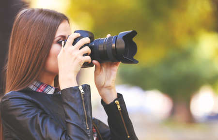 Young photographer taking photos outdoorsの写真素材