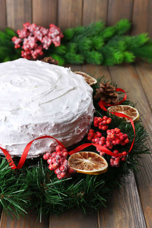 Christmas cake with wreath on wooden backgroundの写真素材