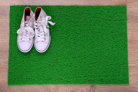 Green carpet on floor and converse close-upの写真素材