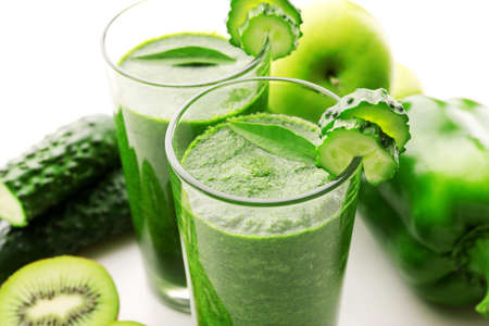Green fresh healthy juice with fruits and vegetables on white backgroundの写真素材