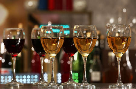 Glasses of wine on counter and bar on backgroundの写真素材