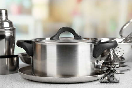 Stainless steel kitchenware on table, on light backgroundの写真素材