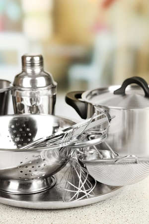 Stainless steel kitchenware on table, on light backgroundの写真素材