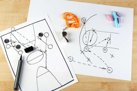 Scheme basketball game on sheet of paper and wooden table backgroundの写真素材