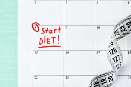 Diet concept - measure tape on calendar, close upの写真素材